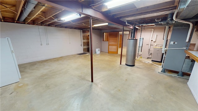 unfinished basement with gas water heater and freestanding refrigerator