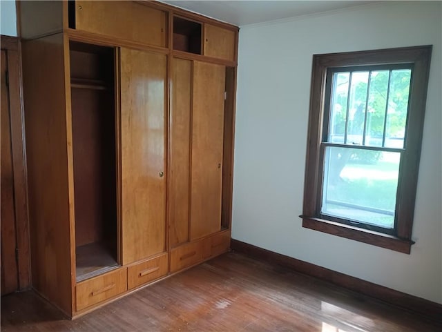 920 Garfield Pl, Danville, IL 61832 - unfurnished bedroom with wood finished floors, ornamental molding, and a closet