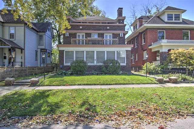 view of front of home featuring a balcony and a front yard