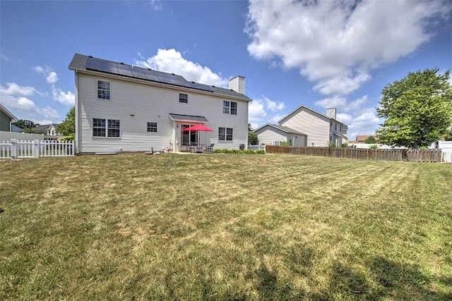 737 Phillip Cir, Forsyth, IL 62535 - back of house with solar panels, a fenced backyard, and a chimney