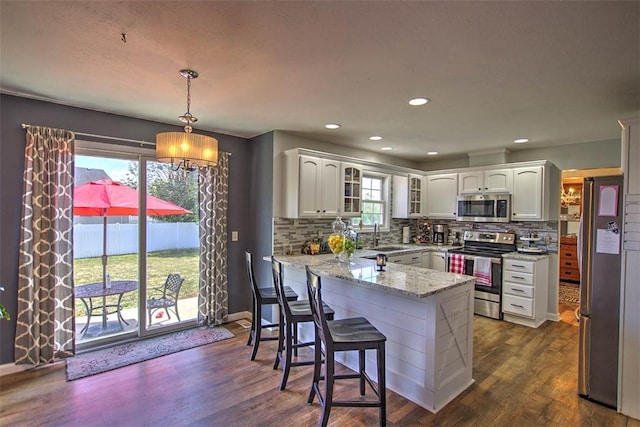 737 Phillip Cir, Forsyth, IL 62535 - kitchen featuring stainless steel appliances, a peninsula, glass insert cabinets, white cabinets, and light stone countertops