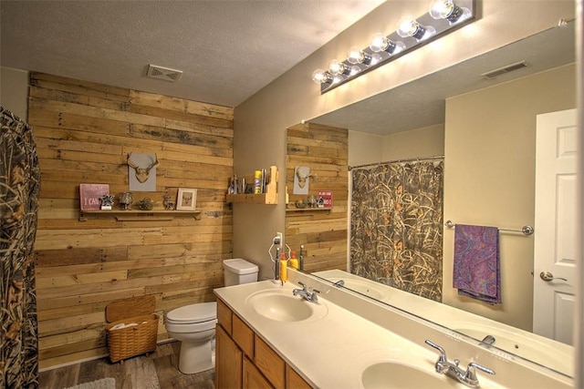 737 Phillip Cir, Forsyth, IL 62535 - full bath featuring wooden walls, wood finished floors, double vanity, curtained shower, and a textured ceiling
