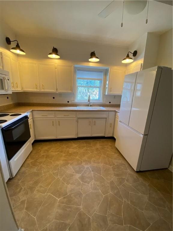 kitchen with white cabinets, white appliances, ceiling fan, and sink