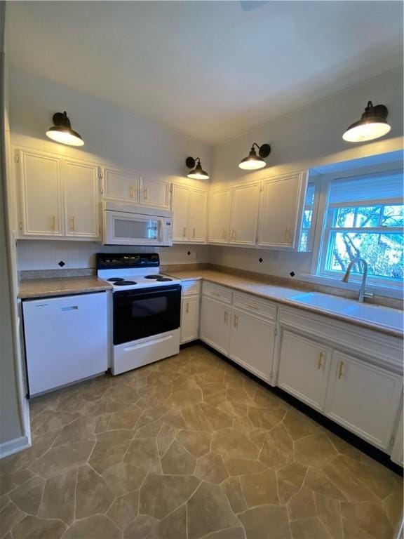 kitchen featuring sink, white cabinets, and white appliances