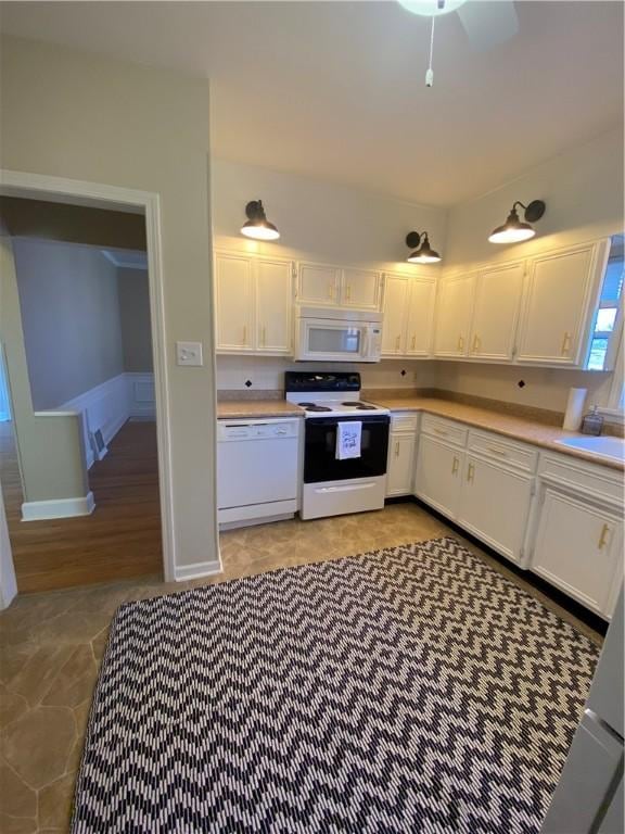 kitchen featuring sink, white cabinets, and white appliances