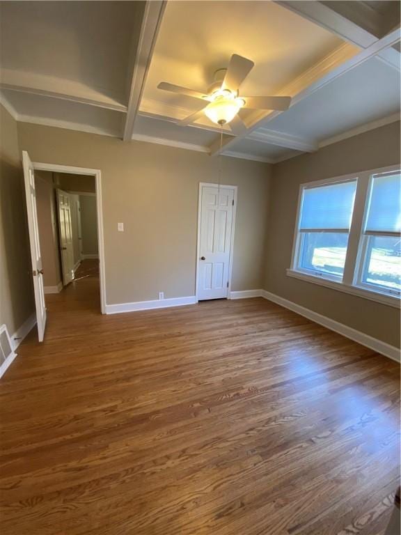 unfurnished bedroom with beamed ceiling, ceiling fan, dark wood-type flooring, and coffered ceiling