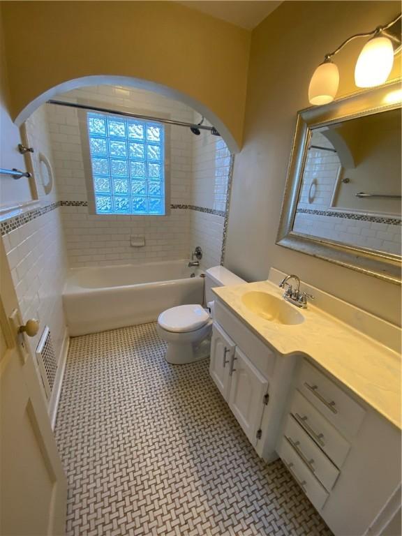 full bathroom featuring toilet, vanity, and tiled shower / bath combo