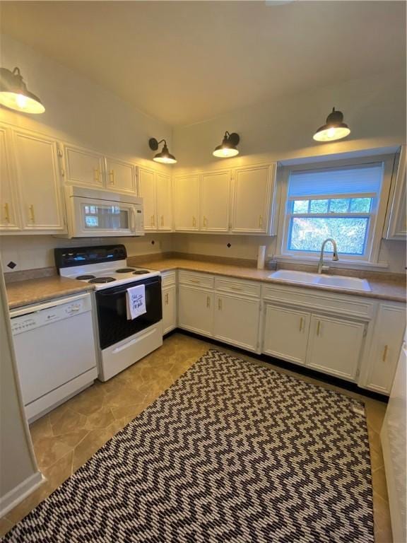 kitchen with white cabinetry, white appliances, and sink