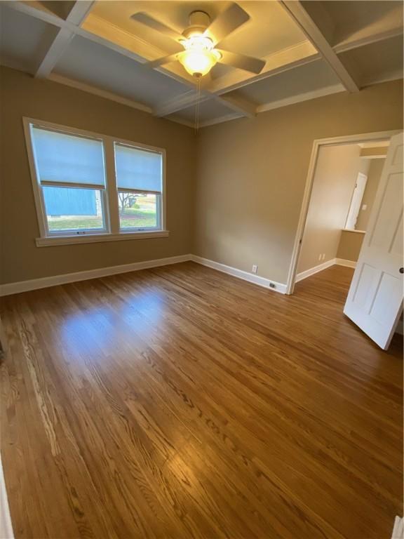 spare room with wood-type flooring, coffered ceiling, and beam ceiling