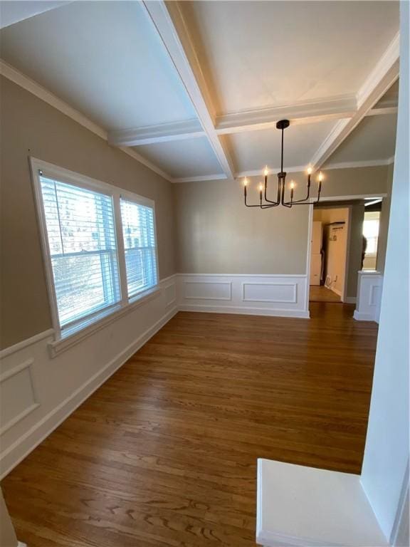 unfurnished dining area featuring ornamental molding, coffered ceiling, beam ceiling, a notable chandelier, and dark hardwood / wood-style floors