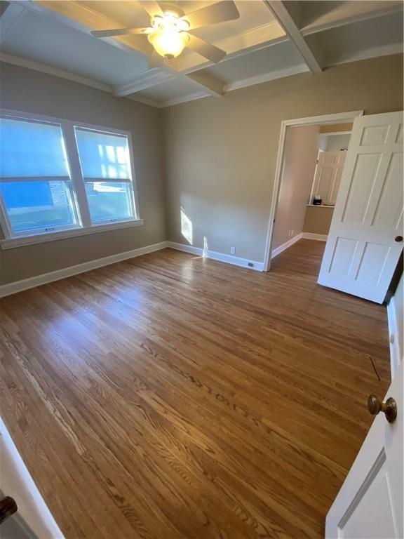 spare room featuring ceiling fan, coffered ceiling, beamed ceiling, and dark hardwood / wood-style floors