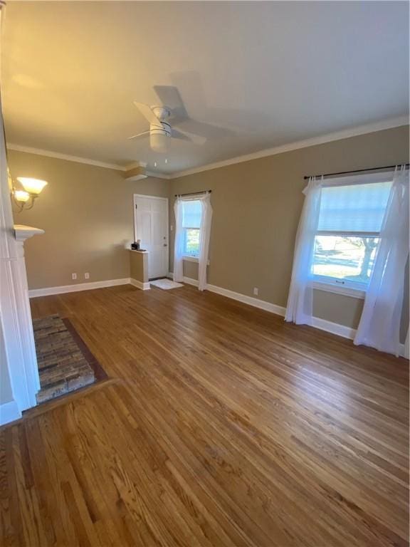 unfurnished living room featuring hardwood / wood-style flooring, a wealth of natural light, and ornamental molding