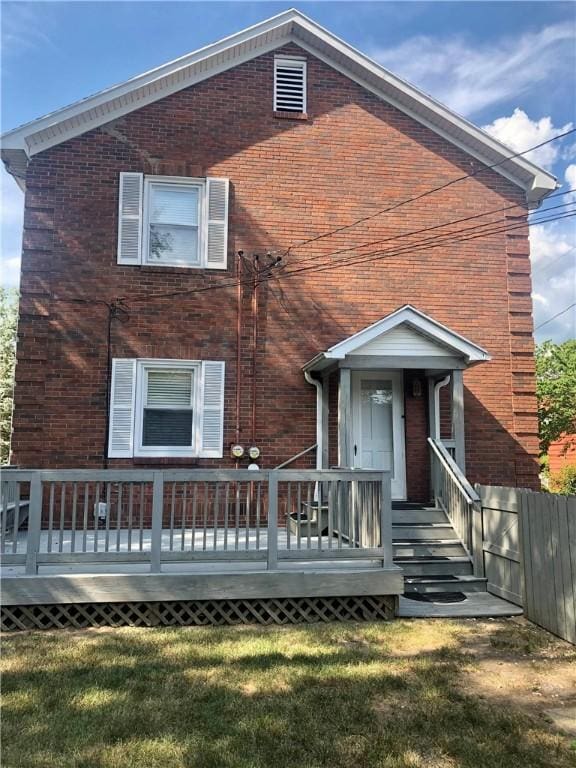 view of front of home with a front yard and a wooden deck