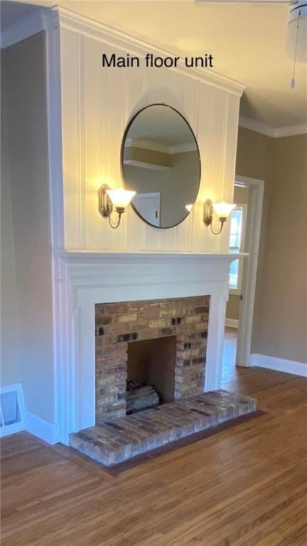 details with hardwood / wood-style floors, crown molding, and a fireplace