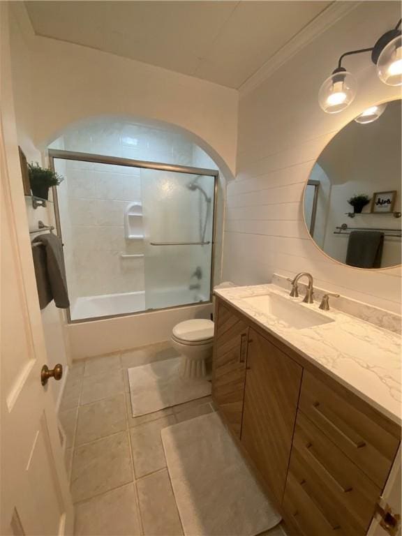 full bathroom featuring shower / bath combination with glass door, vanity, toilet, and tile patterned flooring