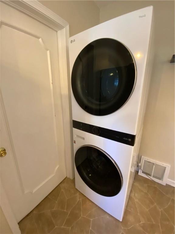 clothes washing area with stacked washer / dryer