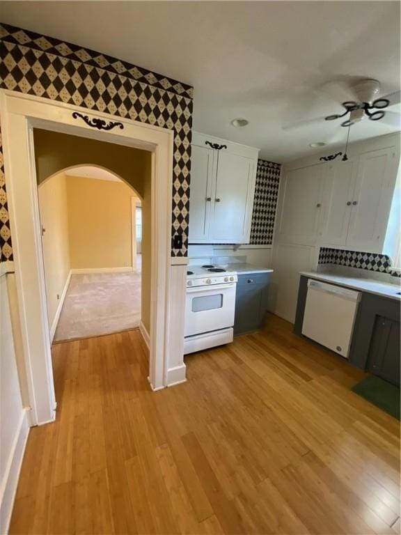 kitchen featuring white cabinetry, light hardwood / wood-style flooring, ceiling fan, and white appliances