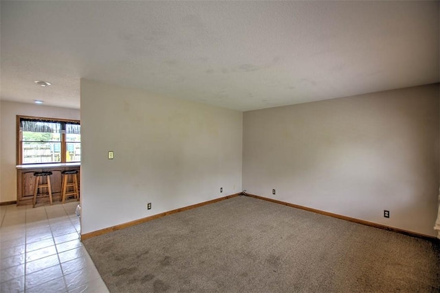 335 E Walnut St, Dalton City, IL 61925 - spare room with baseboards, light carpet, and light tile patterned floors