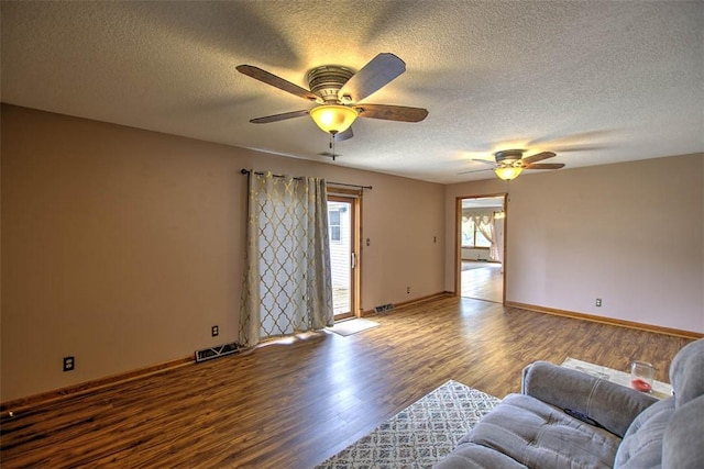 335 E Walnut St, Dalton City, IL 61925 - living room featuring wood finished floors, a ceiling fan, a textured ceiling, and baseboards