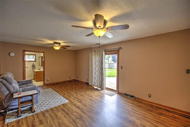335 E Walnut St, Dalton City, IL 61925 - unfurnished living room with wood finished floors, a textured ceiling, ceiling fan, and baseboards