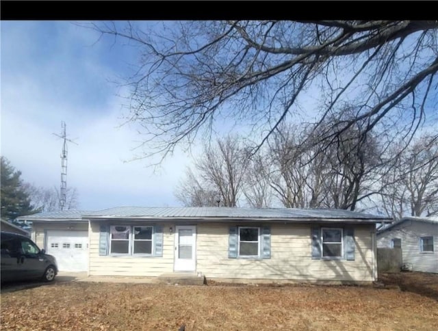 single story home with an attached garage and metal roof