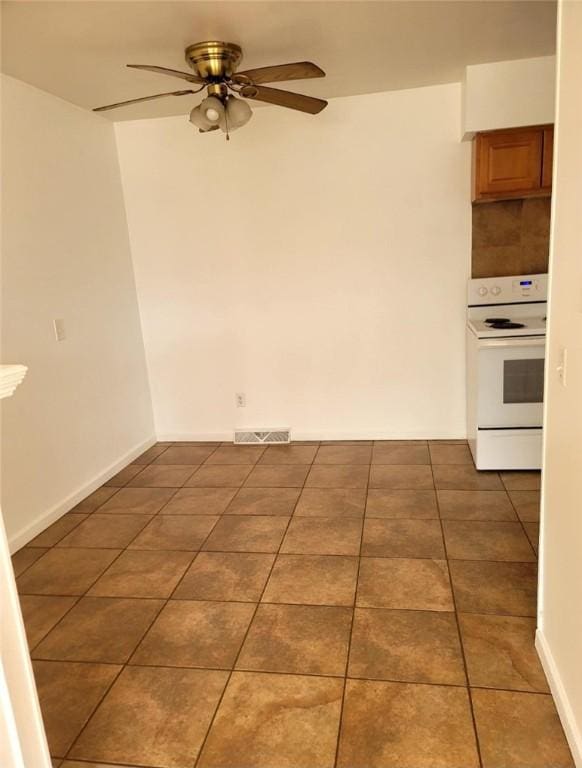 unfurnished room with tile patterned flooring, visible vents, ceiling fan, and baseboards