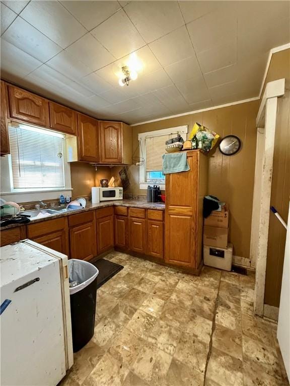 124 Polk Ave, Charleston, IL 61920 - kitchen with brown cabinets, white microwave, and ornamental molding