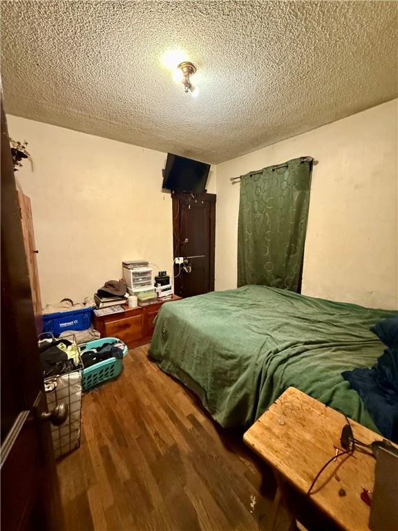 124 Polk Ave, Charleston, IL 61920 - bedroom with a textured ceiling and wood finished floors