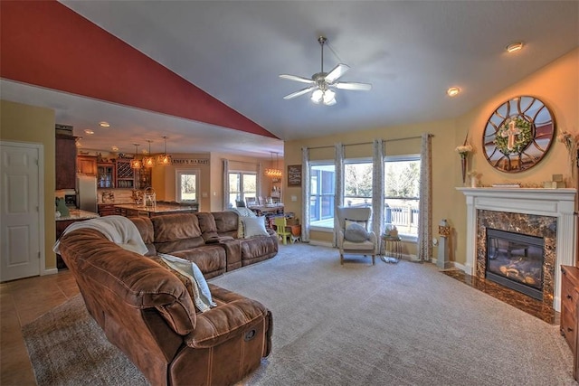 living room with a fireplace, high vaulted ceiling, ceiling fan, and carpet