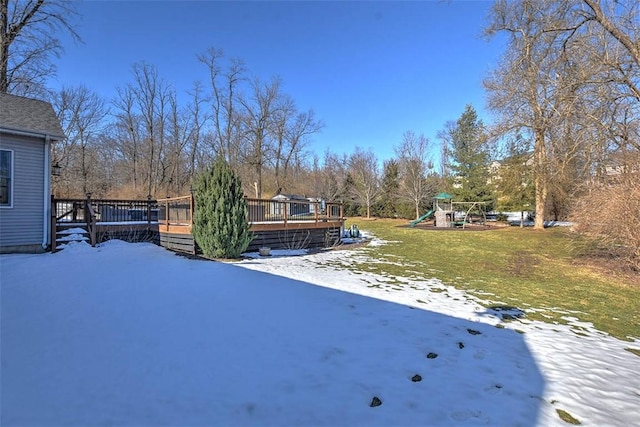 yard covered in snow featuring a playground