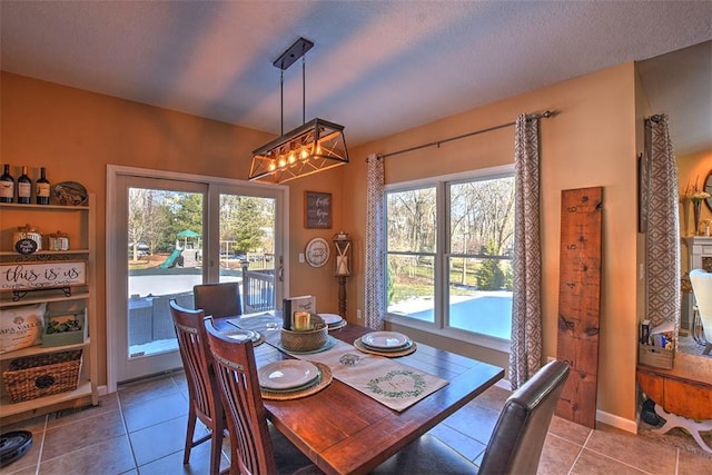 dining room with tile patterned floors, a textured ceiling, and a wealth of natural light