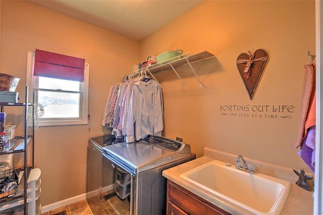 laundry area featuring cabinets, sink, and washing machine and clothes dryer