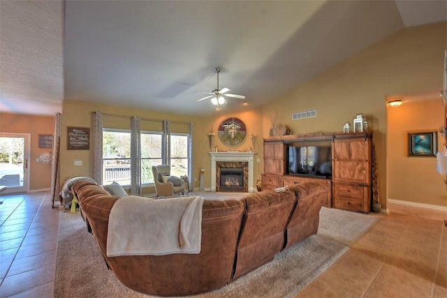 living room featuring tile patterned flooring, lofted ceiling, a premium fireplace, and ceiling fan