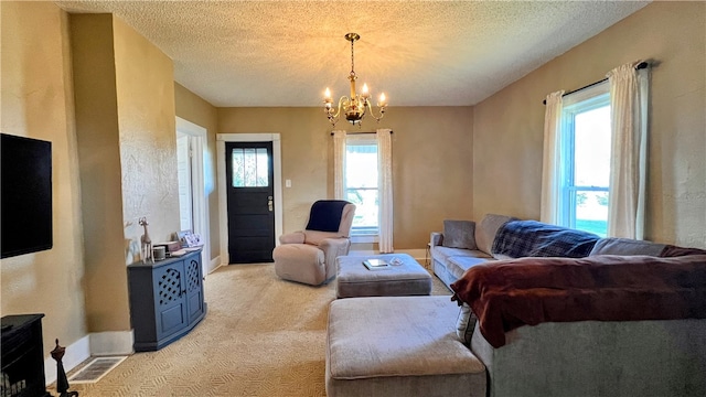 living room with light carpet, a textured ceiling, and a notable chandelier