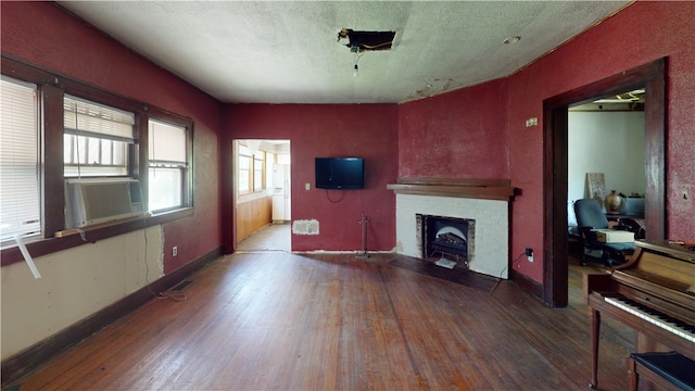 616 Griffin St, Danville, IL 61832 - living area featuring wood finished floors, a brick fireplace, cooling unit, and a textured ceiling