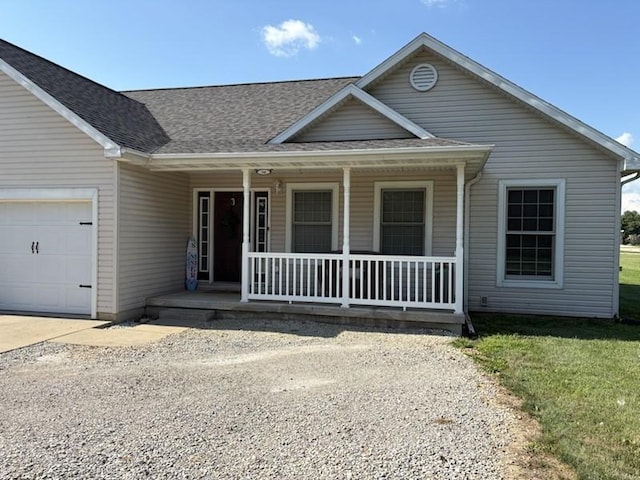 34A Woolery Dr, Neoga, IL 62447 - view of front facade featuring a porch, a garage, roof with shingles, and driveway