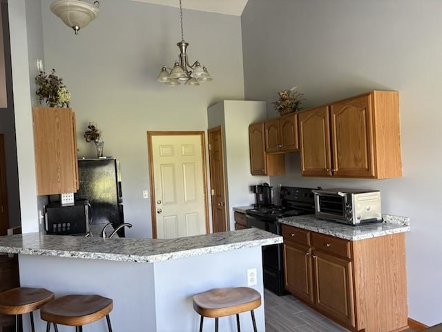34A Woolery Dr, Neoga, IL 62447 - kitchen featuring black electric range oven, a chandelier, a breakfast bar, high vaulted ceiling, and a peninsula