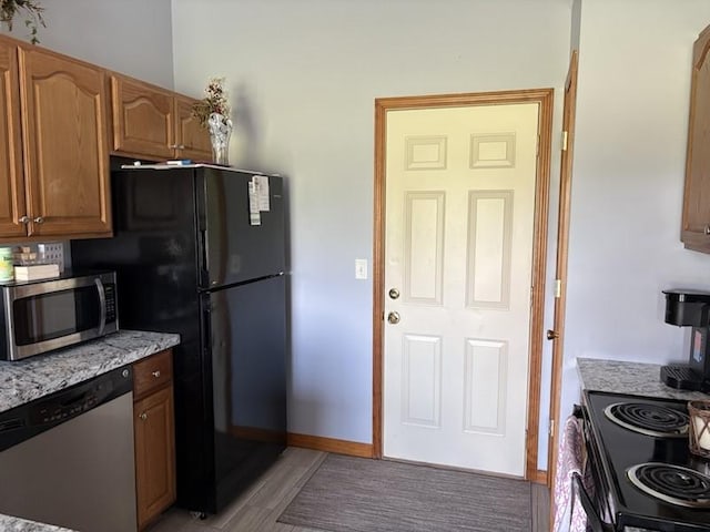 34A Woolery Dr, Neoga, IL 62447 - kitchen with stainless steel appliances, light wood-style floors, brown cabinets, and light stone counters
