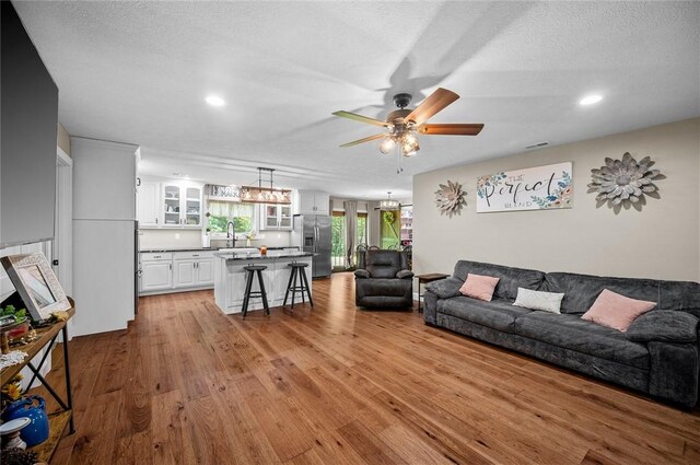 25760 E 1750th Rd, Marshall, IL 62441 - living room featuring a ceiling fan, wood finished floors, recessed lighting, a textured ceiling, and a chandelier