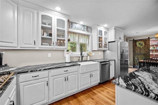 25760 E 1750th Rd, Marshall, IL 62441 - kitchen featuring stainless steel appliances, a barn door, white cabinets, dark stone countertops, and glass insert cabinets