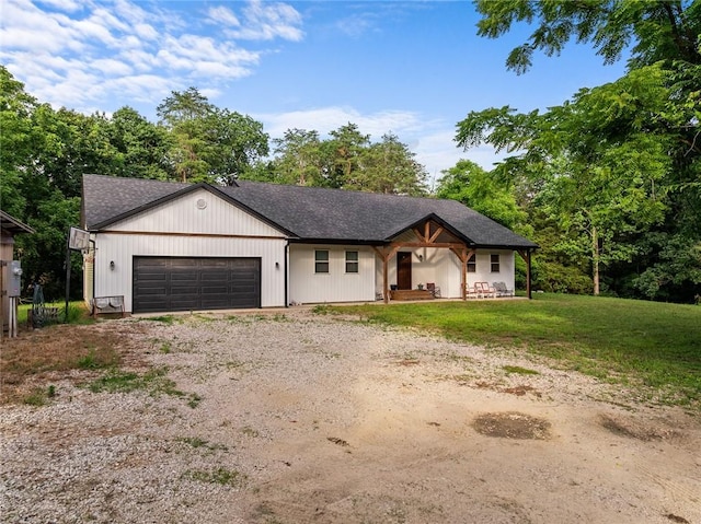 25760 E 1750th Rd, Marshall, IL 62441 - view of front of property featuring driveway, covered porch, an attached garage, a front yard, and view of wooded area