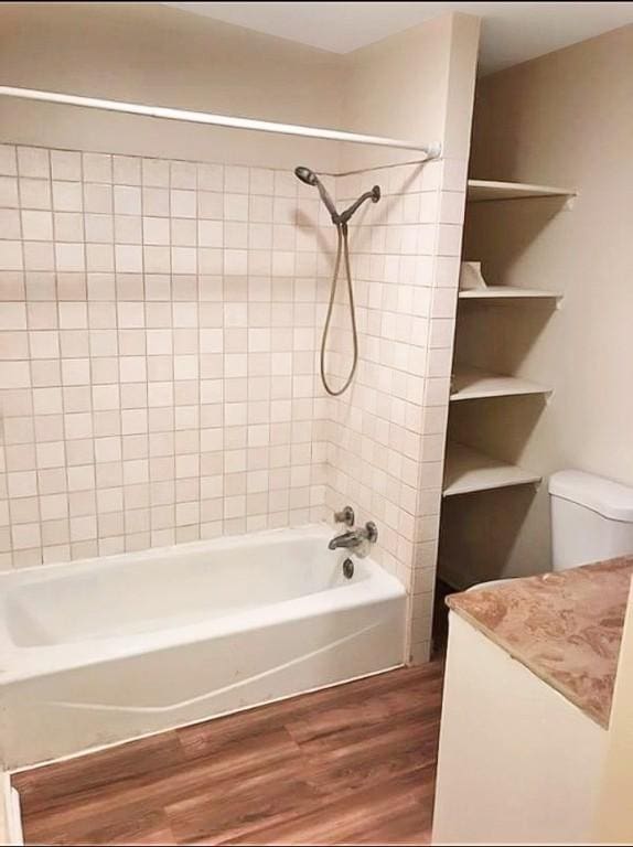 1009 S 14th St, Mattoon, IL 61938 - full bath featuring wood finished floors, shower / washtub combination, vanity, and toilet