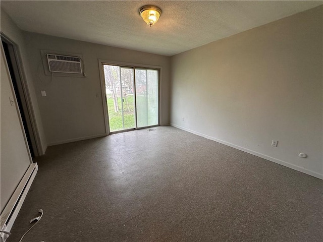 empty room featuring baseboards, a wall unit AC, a textured ceiling, and a baseboard radiator