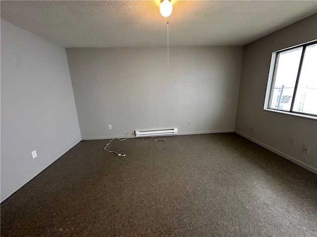 carpeted empty room with a textured ceiling, a baseboard heating unit, and baseboards