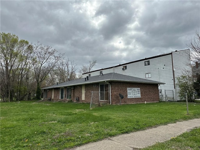 view of side of home featuring brick siding and a lawn