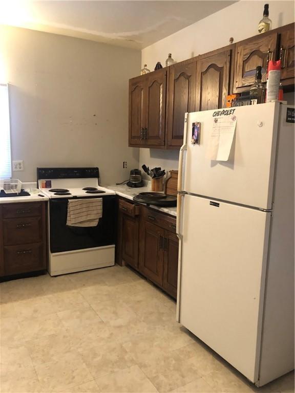 kitchen with white appliances and dark brown cabinetry