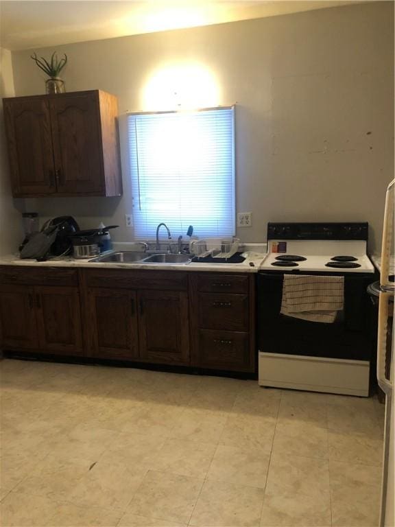 kitchen featuring sink, dark brown cabinetry, and white electric stove