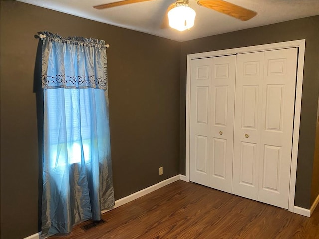 102 10th St, Charleston, IL 61920 - unfurnished bedroom featuring dark wood-style flooring, a closet, and ceiling fan