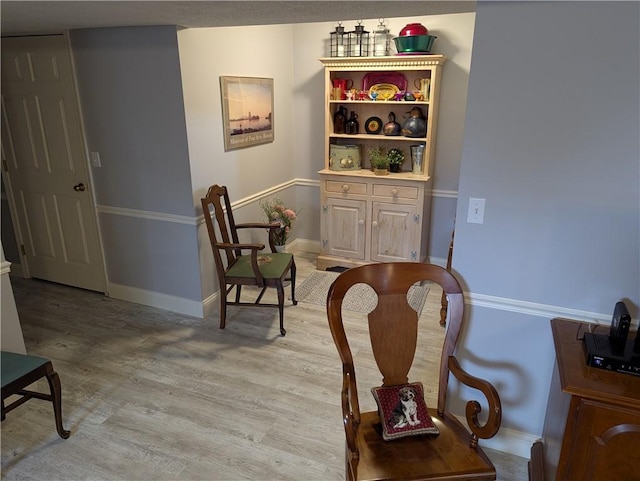 sitting room featuring baseboards and light wood-style floors