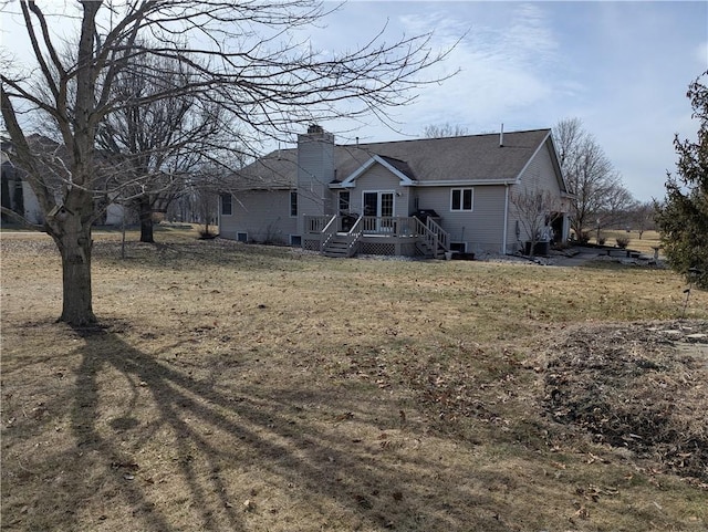 view of front facade featuring a front lawn, a chimney, and a wooden deck